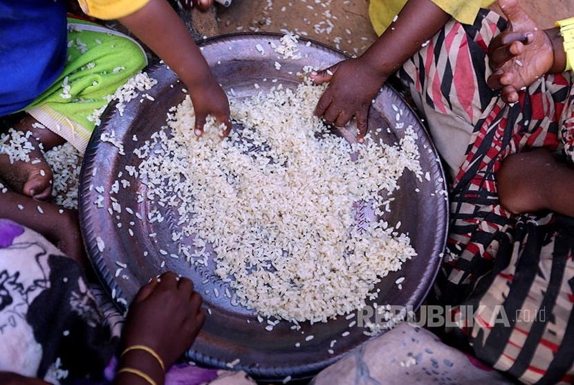 Anak-anak pengungsi menyantap nasi tanpa lauk di kamp pengungsian Al Cadaala, Mogadishu, Somalia.