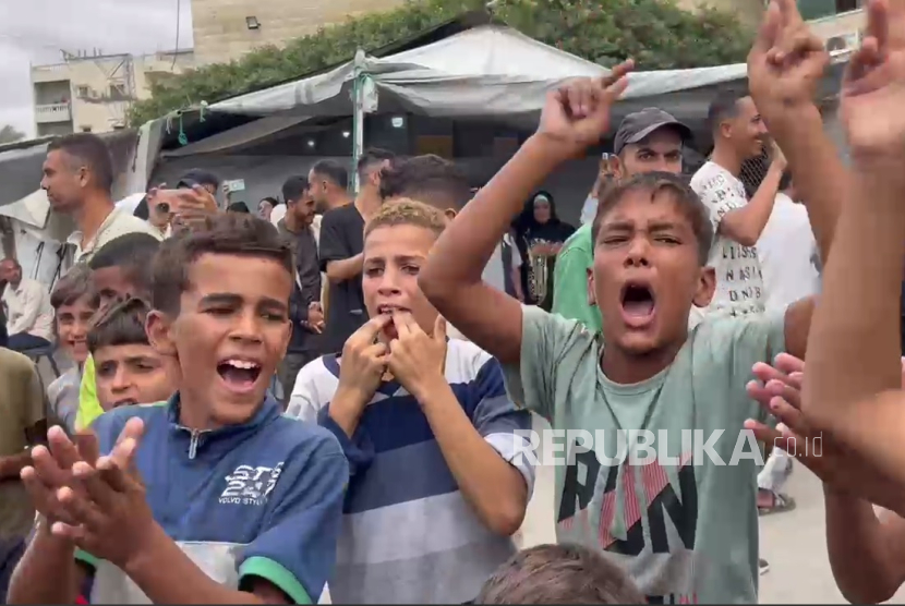 Anak-anak pengungsi merayakan gencatan senjata di Rumah Sakit Syuhada Al Aqsa, Deir Ballah, Jalur Gaza, Jumat (10/10/2025).  