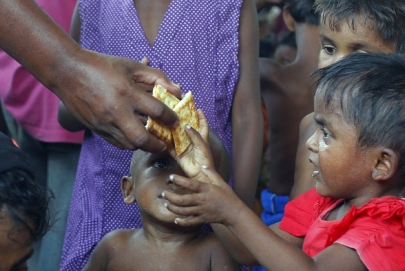 Anak-anak pengungsi Rohingya  berebut biskuit yang dibagikan petugas.