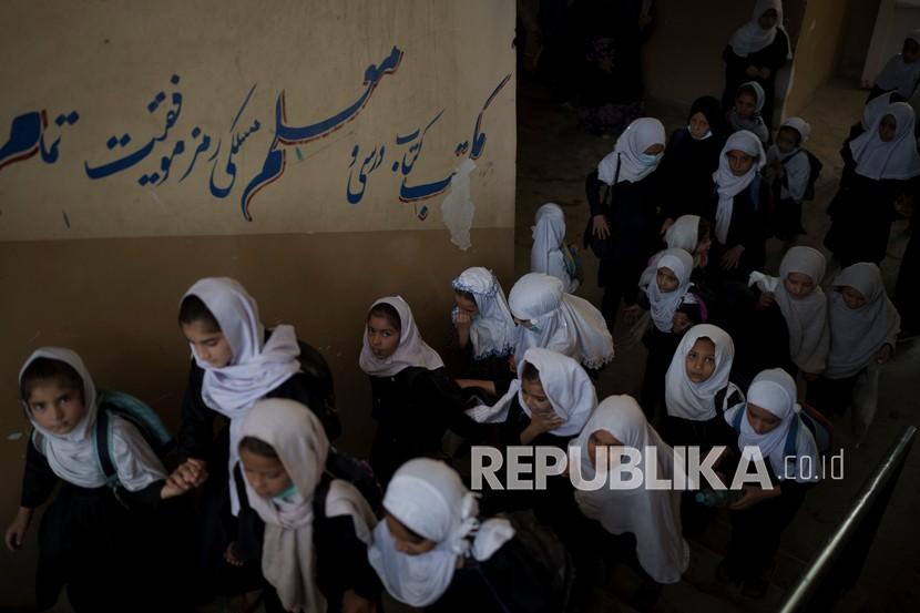 Anak-anak perempuan berjalan ke atas saat mereka memasuki sekolah sebelum kelas di Kabul, Afghanistan