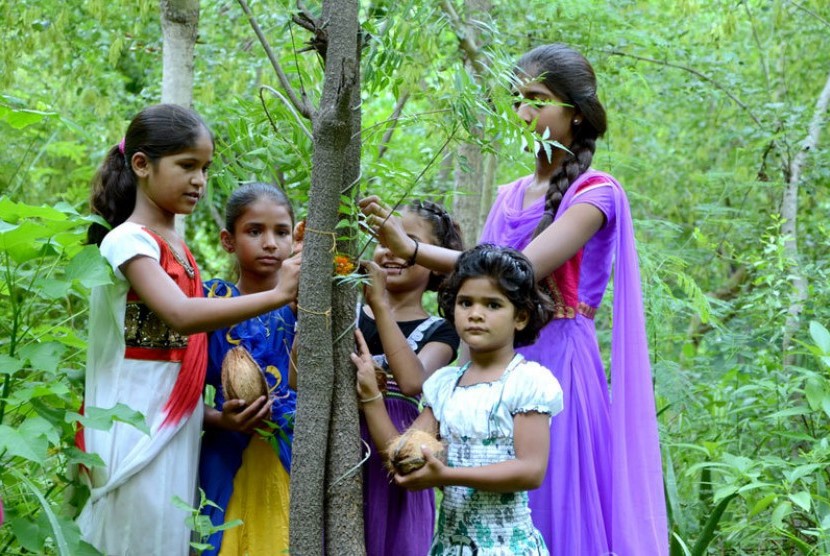 Anak-anak perempuan di Piplantri, India berkumpul di dekat pohon yang masih muda.