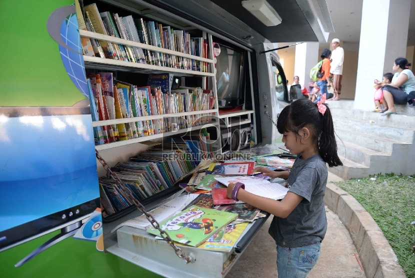 Anak-anak Rusun Jatinegara membaca buku di mobil Perpustakaan Keliling di Rusun Jatinegara, Jakarta, Senin (24/8).  (Republika/Yasin Habibi)