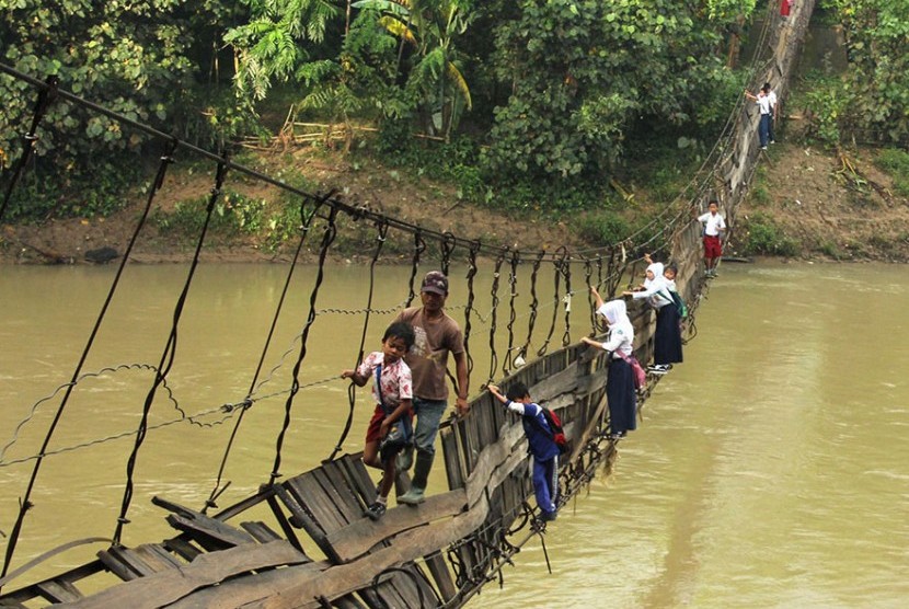 Anak-anak sekolah di Lebak, Banten, meniti jembatan yang rusak yang sangat berbahaya untuk menuju ke sekolah.