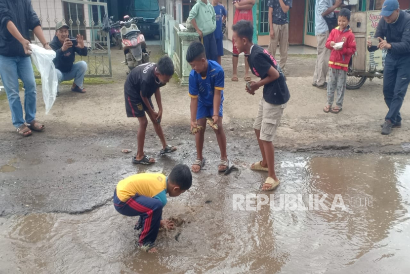 Anak-anak Tengah Mengambil Ikan di Kubangan Air Jalan Rusak di Kampung Cicalung, Desa Wangunharja, Lembang, Kabupaten Bandung Barat (KBB), Jawa Barat.