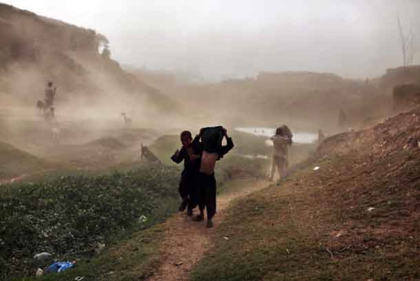  Anak-anak terjebak dalam badai debu di pinggiran kota Islamabad, Pakistan, Selasa (5/6).