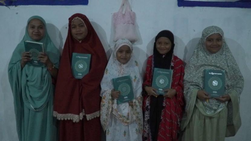 Anak-anak TPQ Jami Darussalam Desa Pinogu, Gorontalo menerima Alquran wakaf dari BWA.