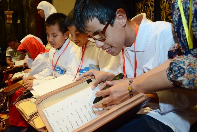 Anak-anak tuna netra mencoba membaca Alquran digital indek braille yang baru didapatkannya, dari Yayasan Baitul Al Khairiyah bekerjasama dengan Kuwait Internasional Bank Al Dawli via International Islamic Charitable Organization, di Bandung, Senin (22/2)