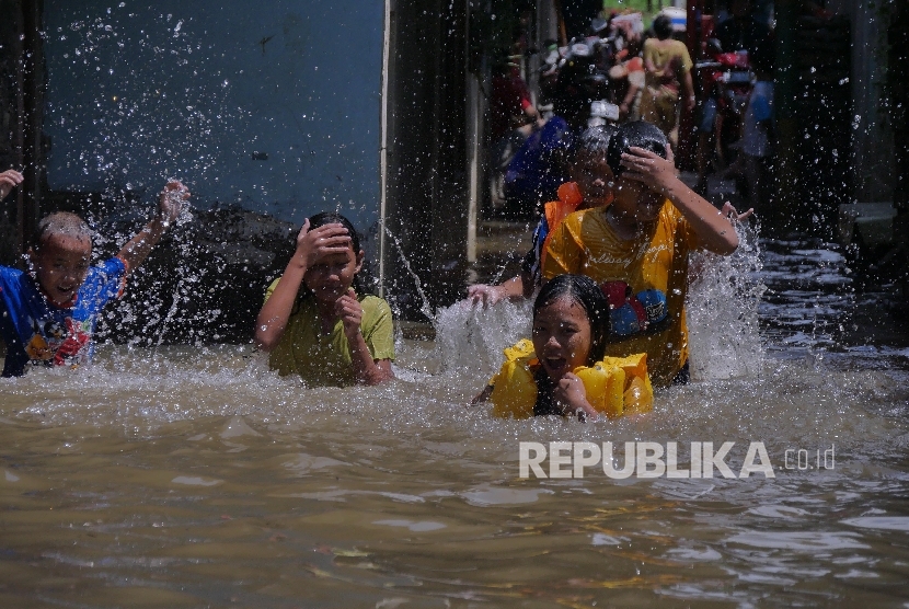 Anak-anak warga sekitar Kali Strada kawasan Pejaten bermain di numahnya yang terendam air banjir setelah hujan deras yang melanda Jakarta Selatan, Kamis (21/4). (Republika/ Yogi Ardhi) 