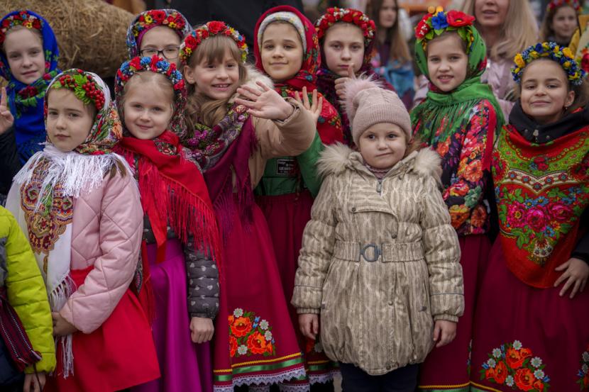 Anak-anak yang mengenakan pakaian tradisional menunggu sebelum membawakan lagu selama pertunjukan tradisi Masnytsia, hari libur yang berasal dari zaman pagan, merayakan akhir musim dingin, di Kyiv, Ukraina, Sabtu, 16 Maret 2024.