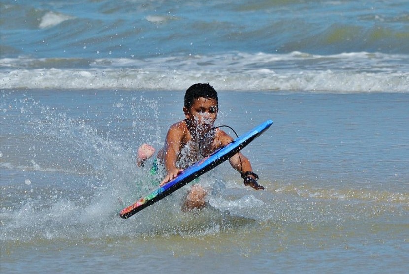 Anak berenang dengan boogie board di laut/ilustrasi.