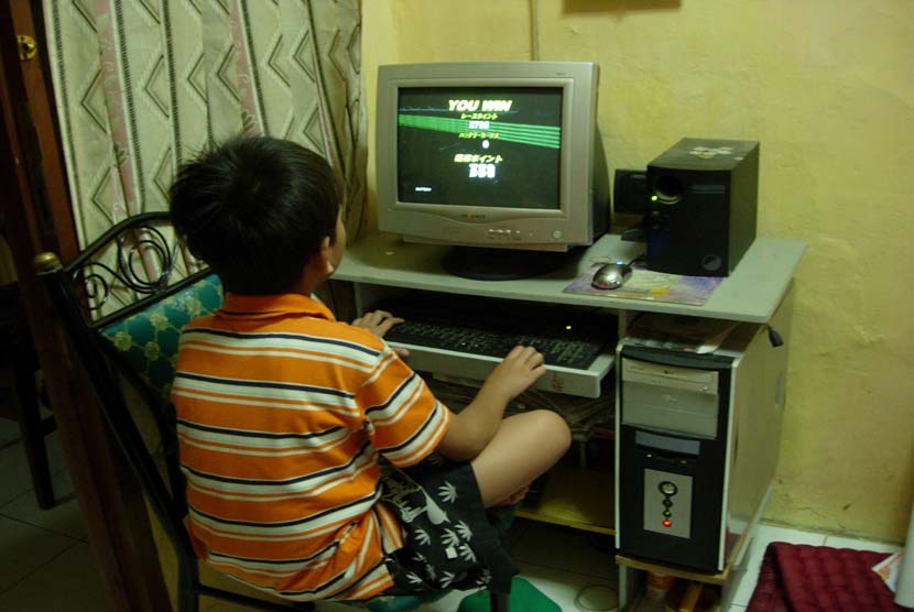 Anak Laki laki yang sedang Main Game di Komputer (ilustrasi).