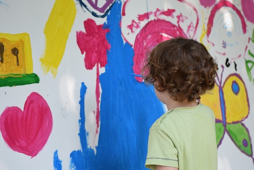 Anak menggambar di dinding.