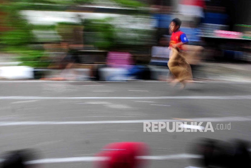 Anak mengikuti lomba balap karung dalam rangka hari kemerdekaan RI.