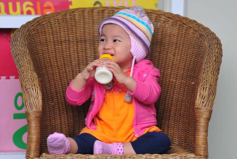 Anak minum susu formula di botol (ilustrasi). Hindari memberikan susu menjelang waktu tidur anak.