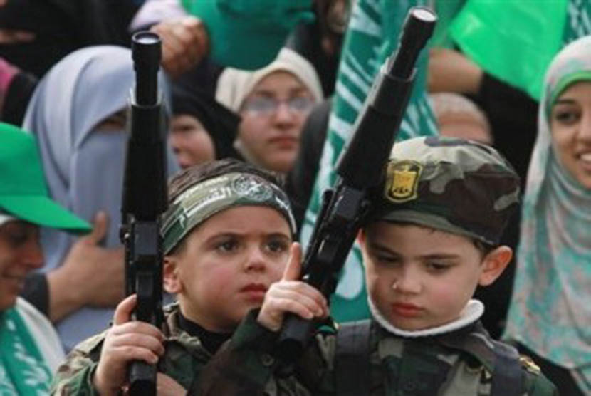 Anak Palestina memegang senjata mainan dalam acara peringatan hari jadi Hamas ke-24 di Gaza City pada Rabu (14/12). 
