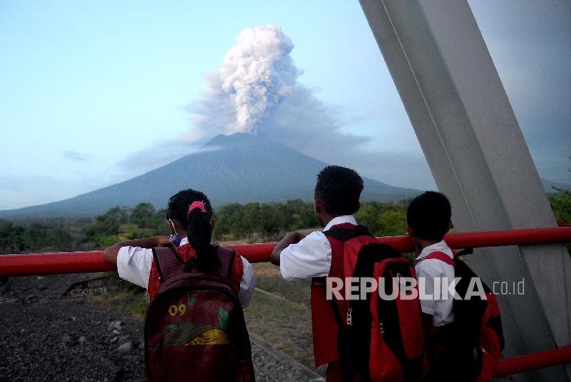Anak sekolah melihat erupsi magmatik Gunung Agung dari Kubu, Karangasem, Bali, Selasa (28/11).