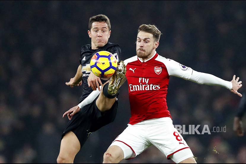 Ander Herrera (kiri) berebut bola dengan Aaron Ramsey (kanan) pada pertandingan Liga Inggris di Emirates Stadium, London, Ahad (3/12) dini hari.