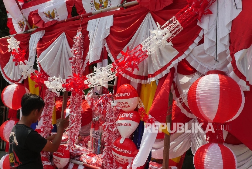 Andi pedagang bendera merah putih dan pernak pernik 17 san, merapihkan jejeran dagangannya yang berada di gerobaknya di kisaran jalan Matraman, Jakarta, Rabu (2/8).