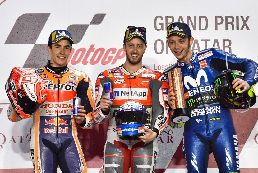 Andrea Dovizioso (tengah), Marc Marquez (kiri), dan Valentino Rossi (kanan) di podium GP Qatar, Ahad (18/3).