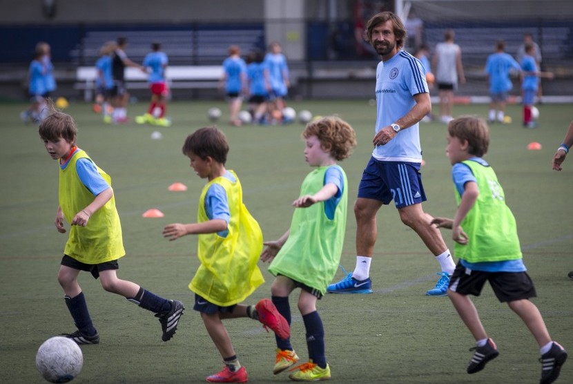 Andrea Pirlo bermain bersama anak-anak ketika menyambangi tempat latihan sepak bola usai diperkenalkan sebagai pemain anyar New York City FC di New York