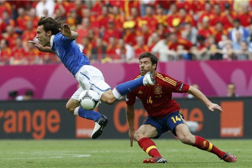  Andrea Pirlo (kiri), gelandang timnas Italia, berjibaku menghadapi hadangan gelandang bertahan Spanyol, Xabi Alonso, di laga perdana Grup C Piala Eropa 2012 di Gdansk, Polandia, pada Ahad )10/6). 