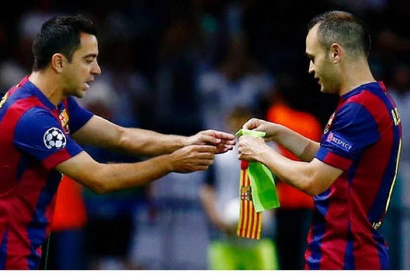 Andres Iniesta (kanan) memberikan ban kapten kepada Xavi saat masih membela Barcelona.