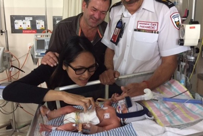 Andrew dan Siripa Day, bersama paramedis Peter James, memandangi bayi Armando Sonny Day yang lahir dalam penerbangan.