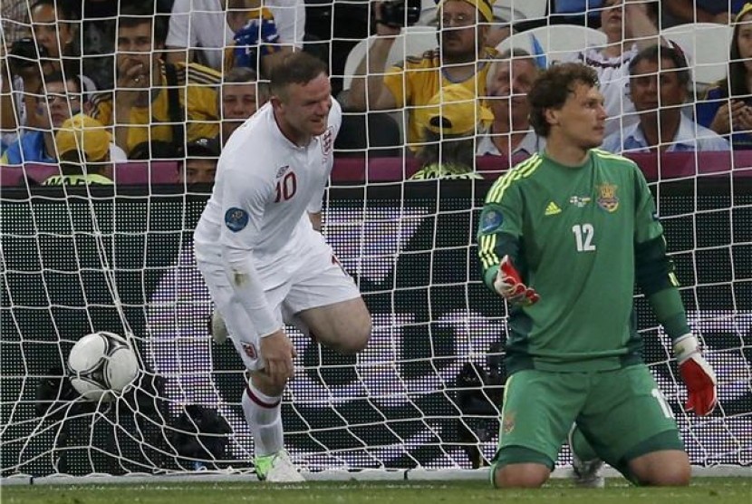  Andriy Pyatov (kanan), kiper timnas Ukraina, terlihat kesal setelah striker timnas Inggris, Wayne Rooney, menjebol gawangnya di laga terakhir Grup D Piala Eropa 2012. 