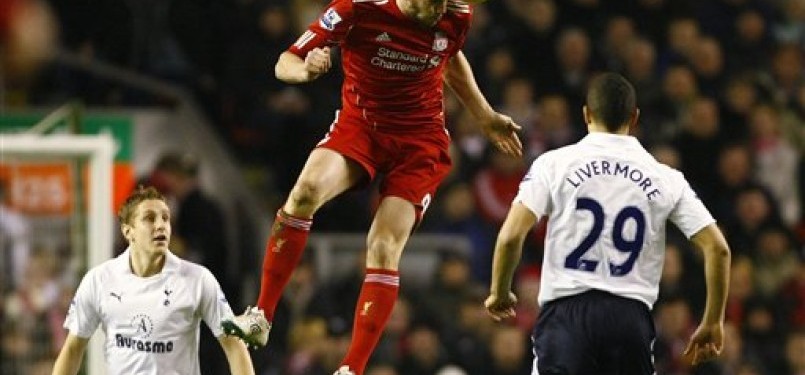 Andy Carroll (tengah), striker Liverpool, melepaskan sundulan saat duel udara dengan pemain Tottenham Hotspur, Michael Dawson (kiri) dan Jake Livermore di laga Liga Primer Inggris di Stadion Anfield, Liverpool, Senin (6/2). 