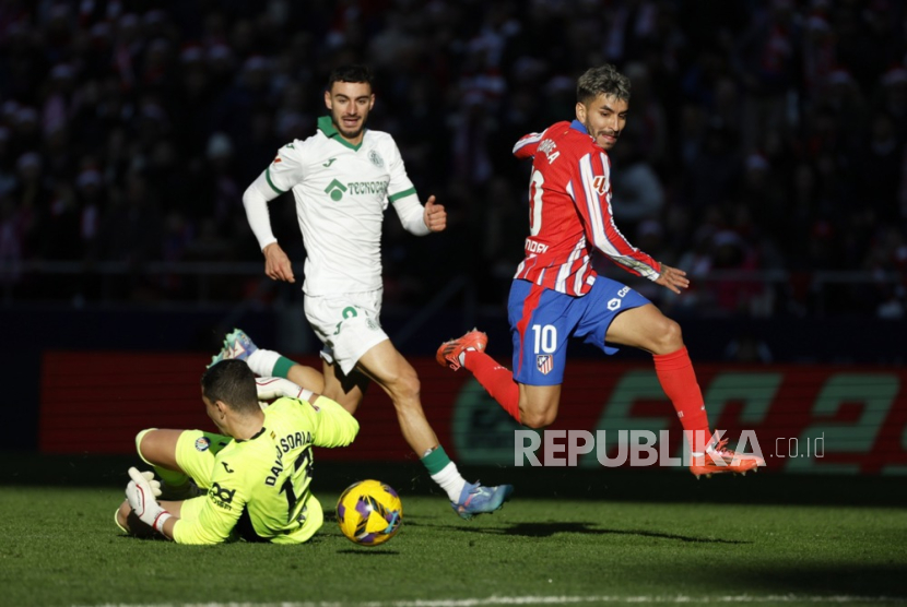 Angel Correa dari Atletico Madrid berebut bola dengan David Soria dari Getafe dalam pertandingan sepak bola La Liga Spanyol di Stadion Riyadh Air Metropolitano di Madrid, Spanyol, Senin (16/12/2024) dini hari WIB.