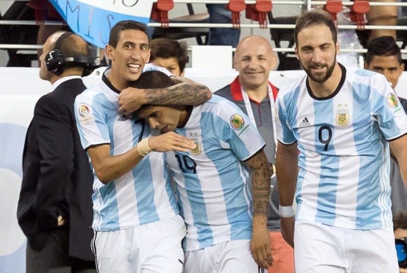 Angel Di Maria (kiri) memeluk Ever Banega yang mencetak gol kemenangan Argentina atas Cile.