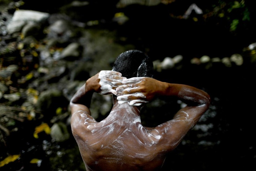 Angel Sanchez mandi di sungai Taman Nasional El Avila di Caracas, Venezuela,Rabu (3/4). Akibat krisis air, warga menyerbu kawasan hutan tersebut.