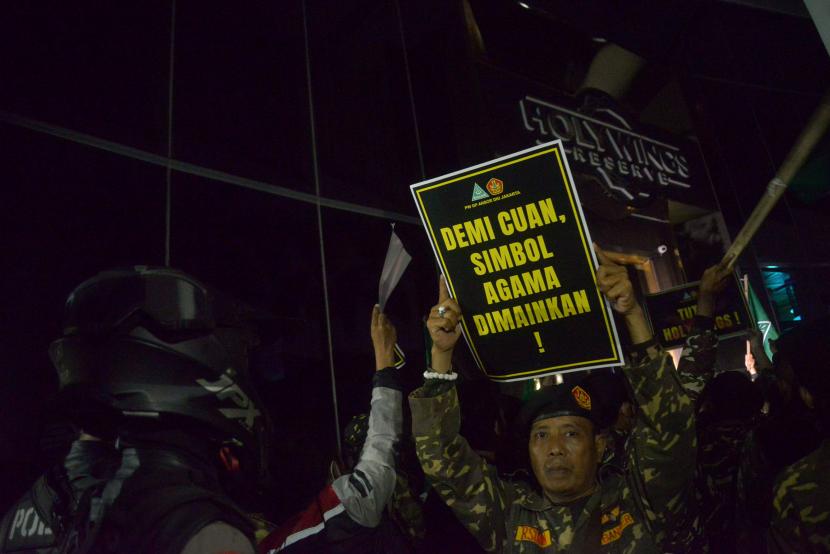 Anggota Barisan Ansor Serbaguna (Banser) DKI Jakarta dengan memegang poster melakukan aksi di depan Holywings, Senayan Jakarta, Jumat (24/6/2022).