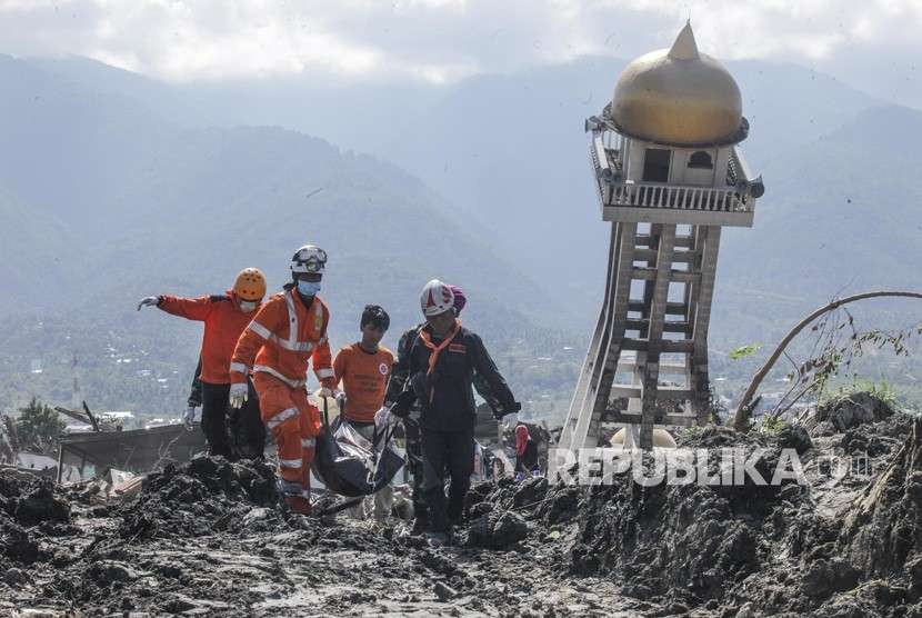 Anggota Basarnas bersama TNI dan relawan membawa kantong berisi jenazah korban gempa dan tsunami di Balaroa, Palu, Sulawesi Tengah, Kamis (4/10). 