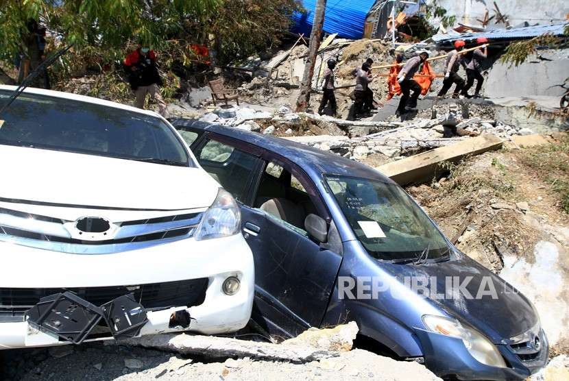 Anggota Basarnas dan Polri mengevakuasi jenazah korban gempa di Petabo, Palu Selatan, Sulawesi Tengah, Senin (1/10).