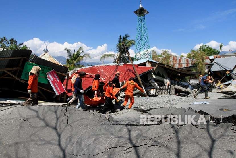 Anggota Basarnas mengevakuasi jenazah korban gempa di Petabo, Palu Selatan, Sulawesi Tengah, Senin (1/10). 