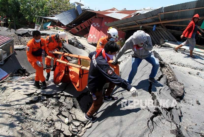 Anggota Basarnas mengevakuasi jenazah korban gempa di Petabo, Palu Selatan, Sulawesi Tengah, Senin (1/10).