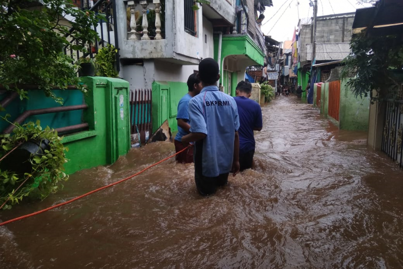 Anggota BKPRMI terjun langsung membantu masyarakat yang tertimpa bencana banjir.