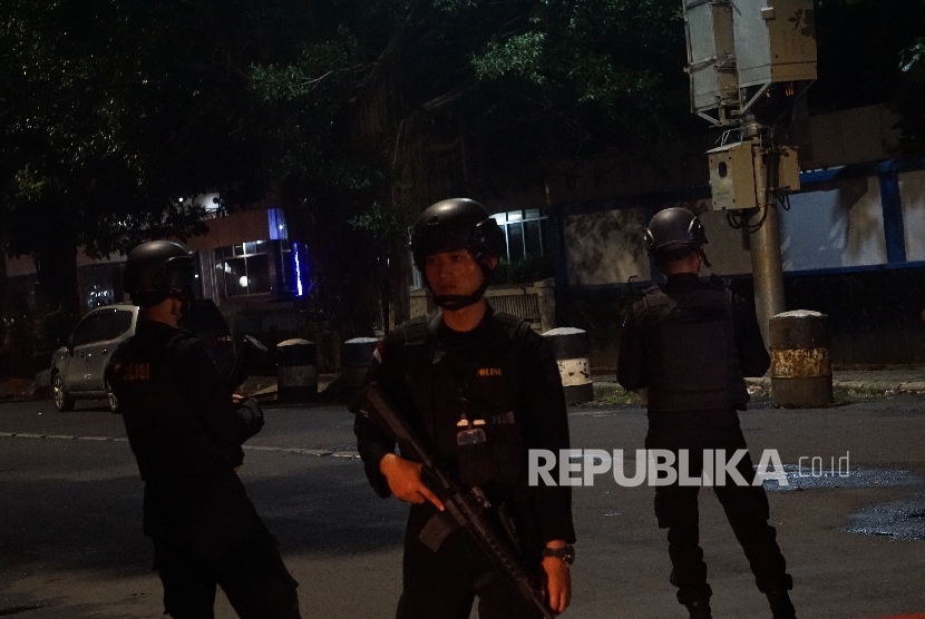 Anggota Brimob berjaga di sekitar tempat kejadian perkara penikaman anggota polisi di depan Masjid Falatehan , Jakarta Selatan, Jumat (30/6). 