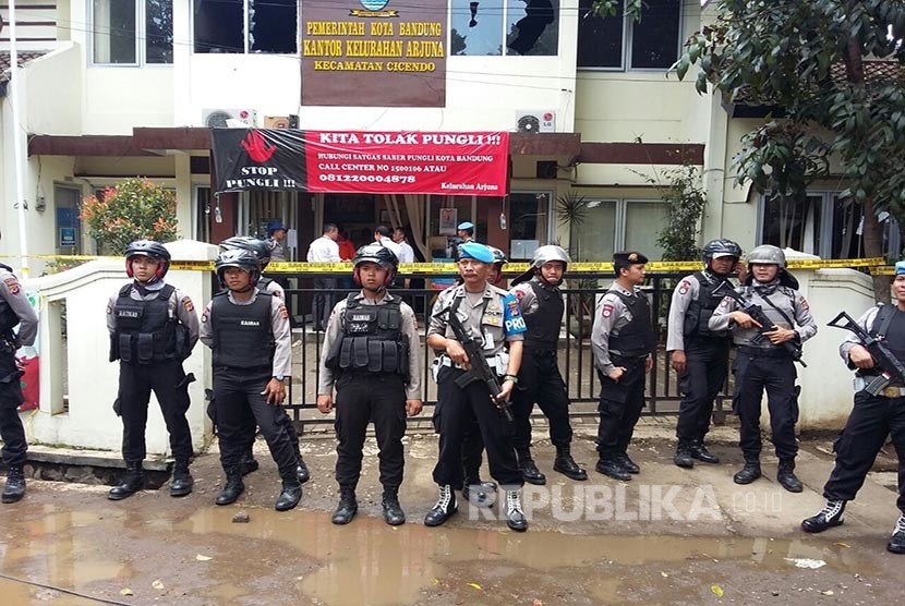 Anggota Brimob  berjaga mengamankan Kantor Kelurahan Arjuna, Pasca pelaku peledakan dibawa menggunakan Ambulance, Jalan Ajuna, Kota Bandung, Senin (27/2).