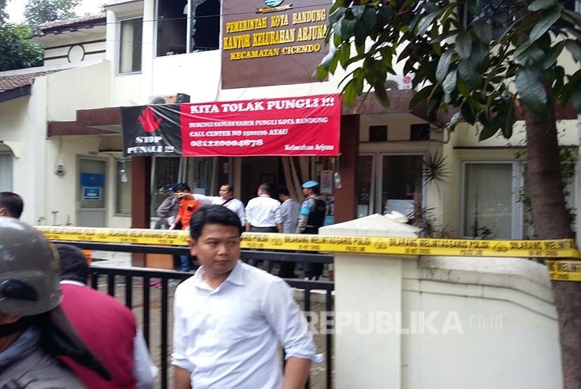 Anggota Brimob  berjaga mengamankan Kantor Kelurahan Arjuna, Pasca pelaku peledakan dibawa menggunakan Ambulance, Jalan Ajuna, Kota Bandung, Senin (27/2).