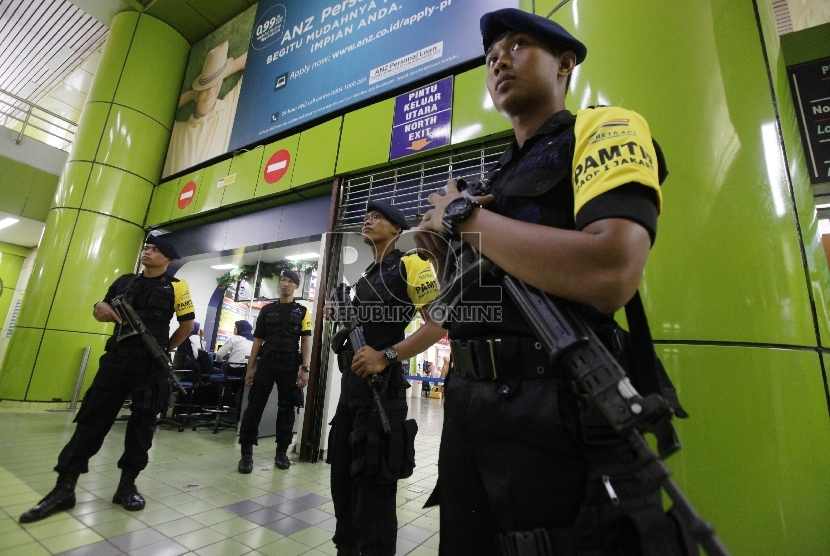 Anggota Brimob melakukan pengamanan Stasiun Gambir menjelang liburan Natal dan Tahun Baru 2015 di lapangan parkir Stasiun Gambir, Jakarta, Ahad (19/12). (Republika/Rakhmawaty La’lang)