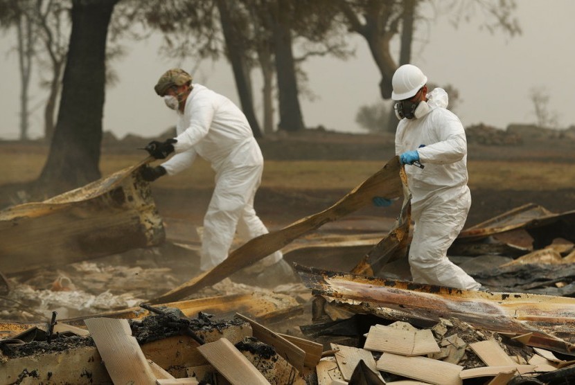 Anggota California Army National Guard mencari korban di sisa rumah yang terbakar di Paradise, Kalifornia, akibat kebakaran hutan, Rabu (14/11).