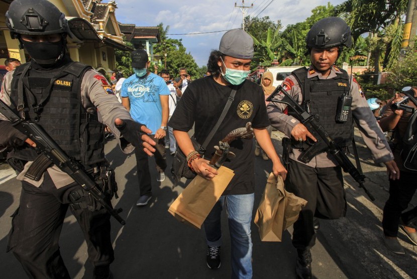 Anggota Datasemen Khusus (Densus) 88 antiteror Mabes Polri membawa barang bukti milik terduga teroris jaringan Nur Rohman, Haryanto alias Hasan di Makam Haji, Sukoharjo, Jawa Tengah, Selasa (19/7).