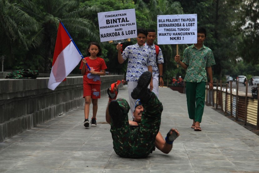 Anggota Detasemen Polisi Militer IV/4 Solo, Kopral Kepala (Cpm) Partika Subagyo Lelono beserta sejumlah anak menggelar Aksi Tolak Narkoba dan LGBT di Solo, Jawa Tengah, Rabu (24/2). 