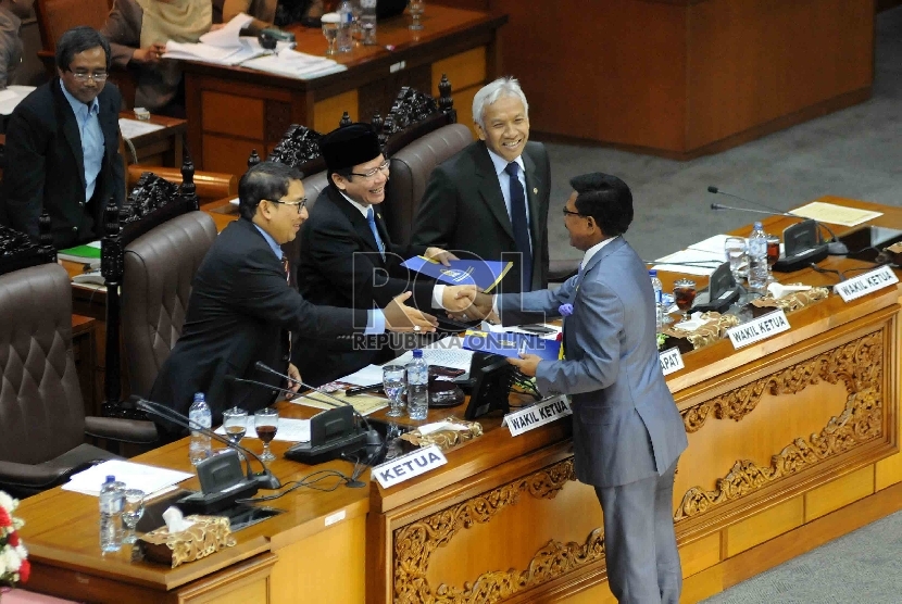 Anggota Dewan Perwakilan Rakyat (DPR) Fraksi Partai Nasdem, Jhonny G Plate menyerahkan pandangan fraksi terhadap nota keuangan RPABN 2016 kepada Wakil Ketua DPR Taufik Kurniawan (tengah) saat mengikuti rapat paripurna di Gedung Nusantara II, Kompleks Parle