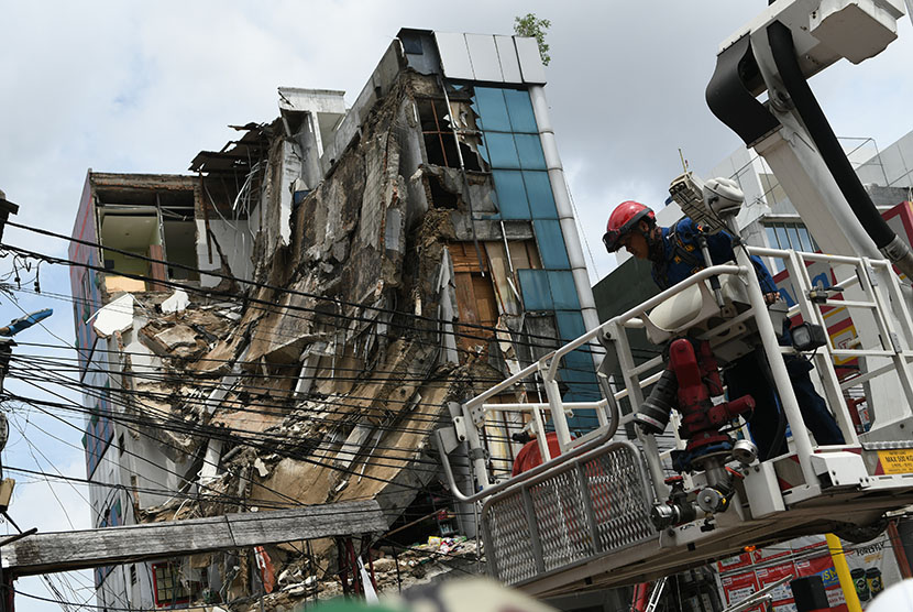 Anggota Dinas Penanggulangan Kebakaran dan Penyelamatan Provinsi DKI Jakarta bersiap melakukan evakuasi terhadap bangunan yang ambruk di Jalan Brigjen Katamso, Kota Bambu Selatan, Palmerah, Jakarta Barat, Senin (6/1/2020).