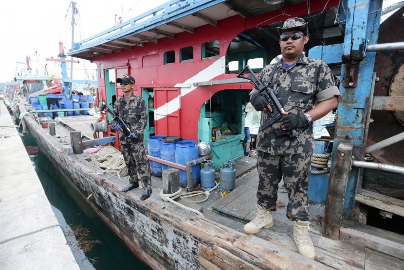 Anggota Ditjen Pengawasan Sumber Daya Kelautan dan Perikanan (PSDKP) Batam menjaga tiga kapal nelayan asing asal Malaysia yang ditangkap bersama 13 awak kapal di Batam, Kepulauan Riau, Senin (7/3).