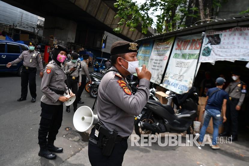 Anggota Ditsamapta Polda Metro Jaya melakukan sosialisasi protokol kesehatan di Pasar Pagi Asemka, Jakarta Barat, Rabu (27/5/2020). Sosialisasi protokol kesehatan di sektor niaga tersebut untuk menuju tatanan normal baru sehingga masyarakat dapat dan terbiasa menjalankan protokol yang telah ditetapkan pemerintah.