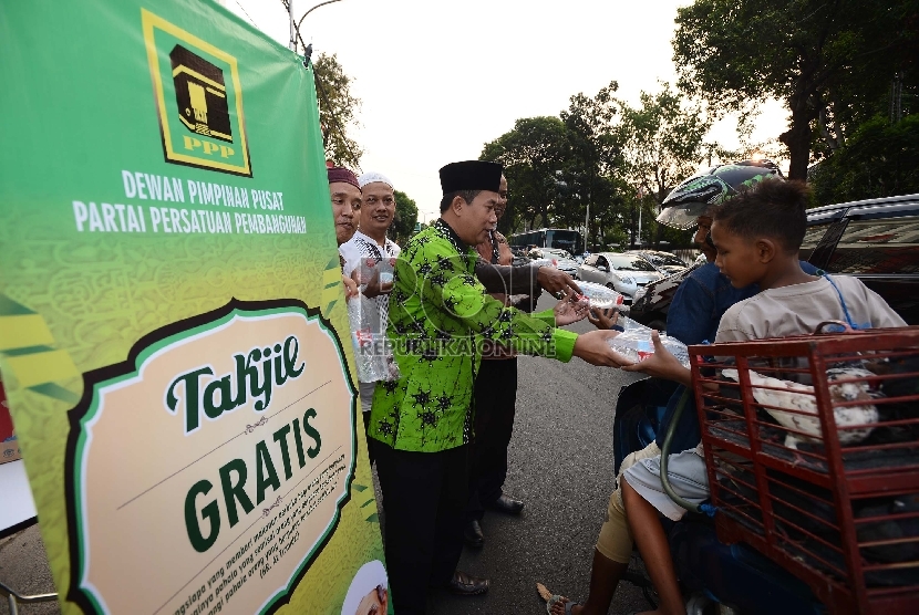 Anggota DPP PPP membagikan takjil kepada pengendara yang melintasi Jalan Diponegoro, Jakarta Pusat, Selasa (30/6). 